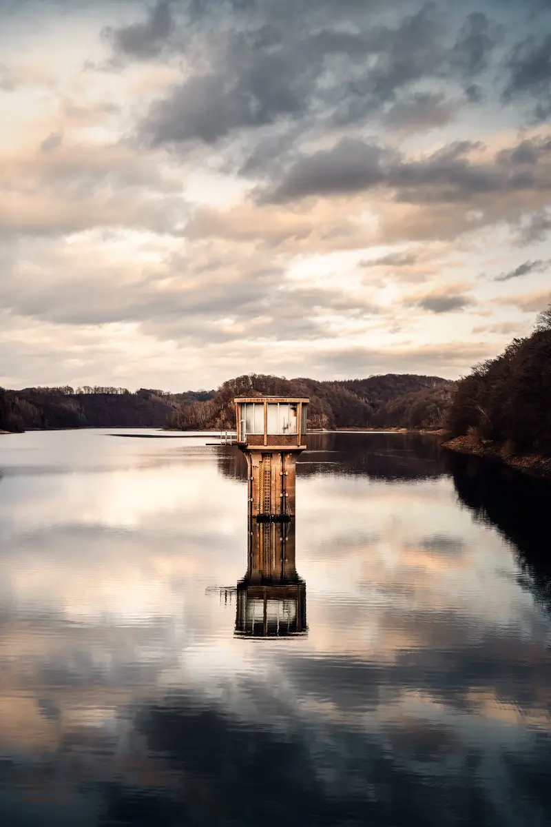 Turm im Wasser bei dramatischem Abendhimmel.