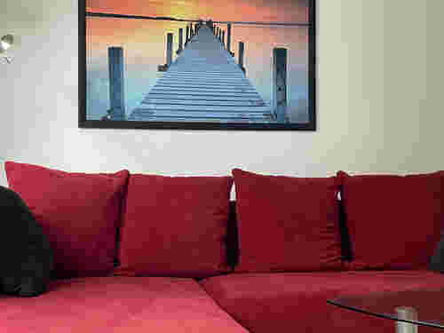 rotes Sofa mit einem Gemälde drüber rotes Sofa mit einem Gemälde drüber